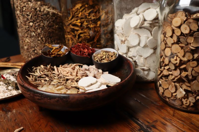 Assorted traditional Chinese herbs and spices in jars and bowls
